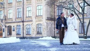 冬季婚礼。 新婚夫妇穿着婚纱，走在白雪覆盖的公园里，背景是